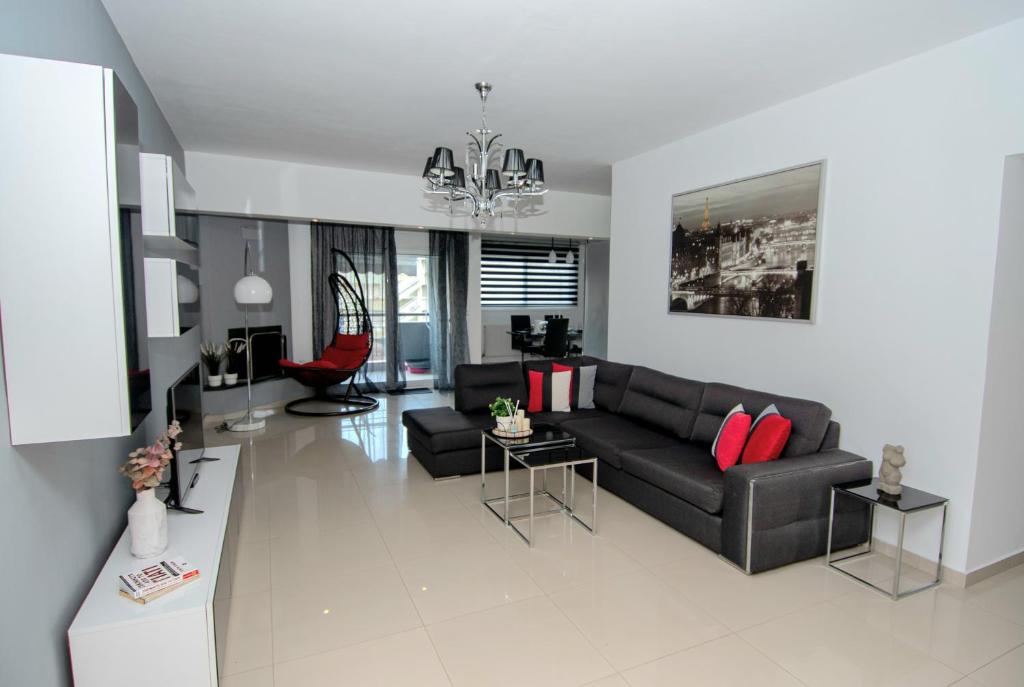 尼亚普拉莫斯Mistral Luxury Living的客厅配有黑色沙发和红色枕头