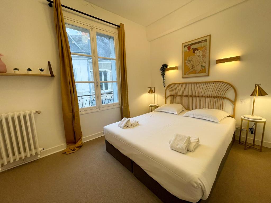 圣艾尼昂Maison des fleurs的卧室配有一张大白色床和窗户
