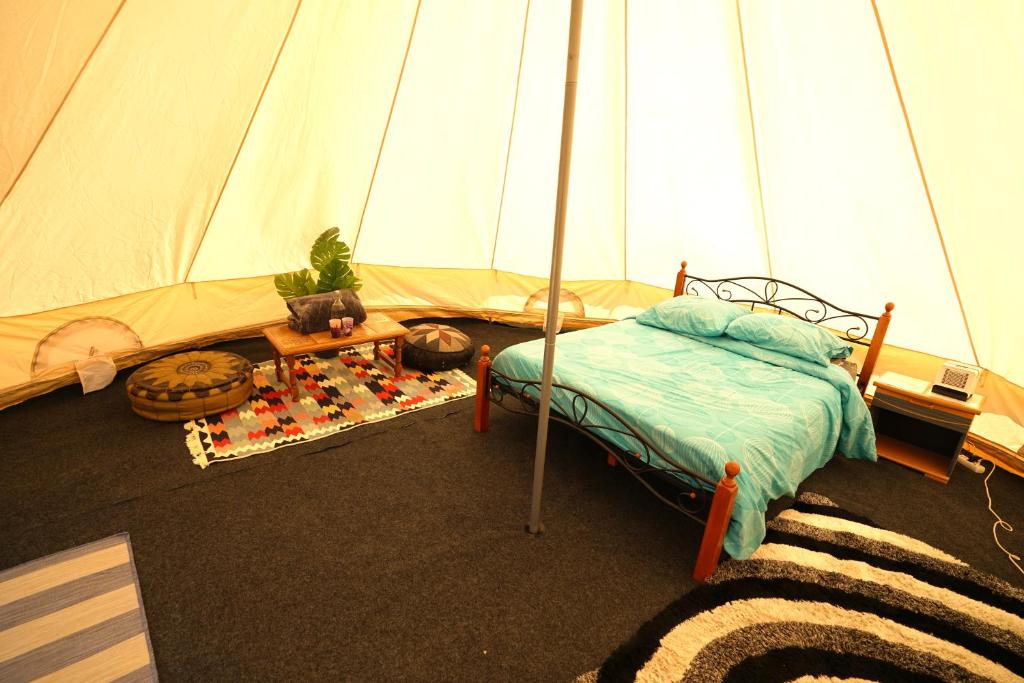 蒙塔尼亚克Camping Arbre de Vie的一间卧室配有一张床和一个帐篷