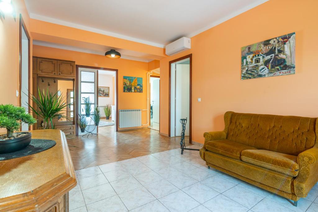 奥帕提亚Apartments Virna的带沙发和橙色墙壁的客厅