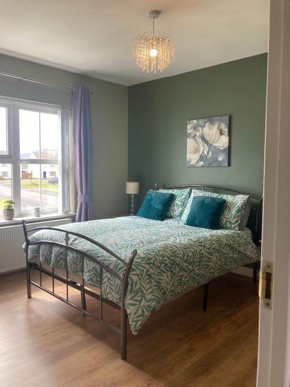 班多伦2 Sea crest Bundoran的一间卧室配有一张带蓝色床单和吊灯的床。