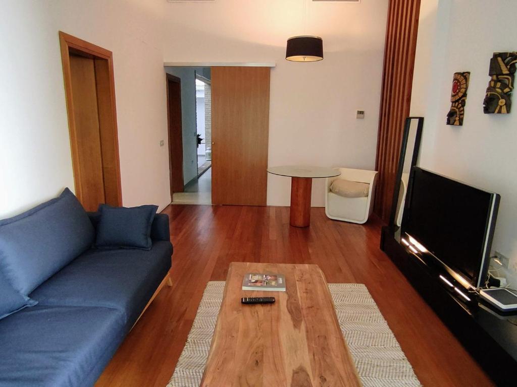 塞维利亚Apartamento Un Jardin en la Alfalfa - Kainga Homes的客厅配有蓝色的沙发和茶几