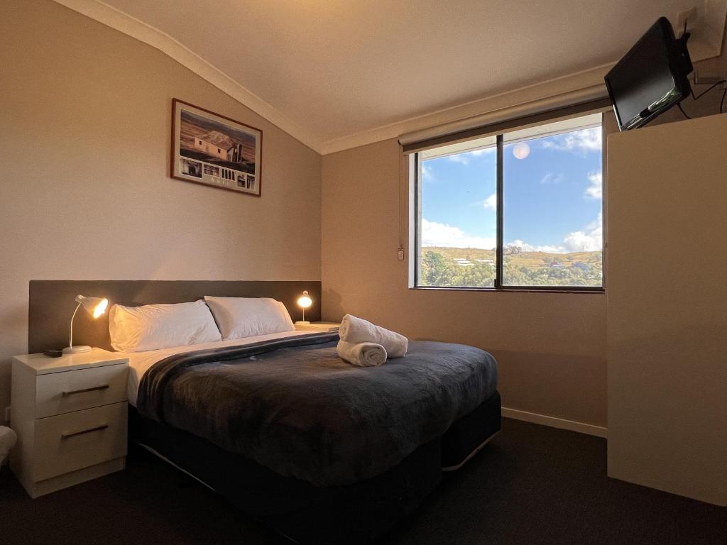 金德拜恩Yuki Inn Jindabyne的一间卧室设有一张大床和一个窗户。