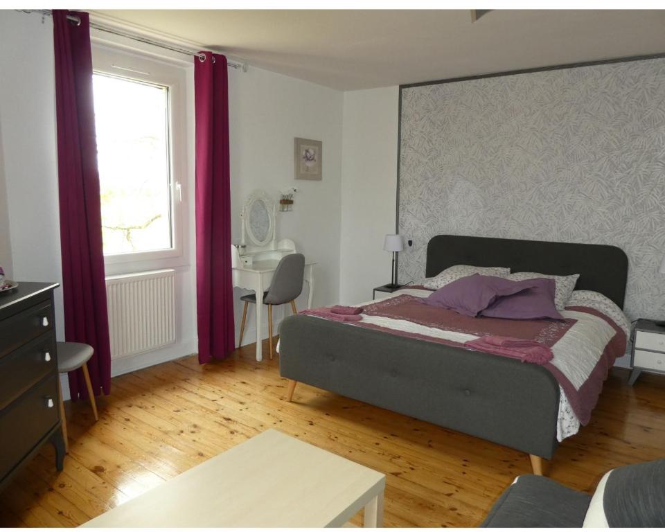 Senouillac拉威格尼洛尼尚布里斯住宿加早餐旅馆的一间卧室配有一张带紫色窗帘的床和一张书桌。