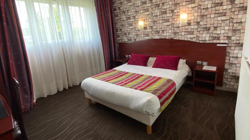 莫尔莱The Originals City, Hôtel Fontaine, Morlaix的一间卧室配有一张带红色枕头的大床