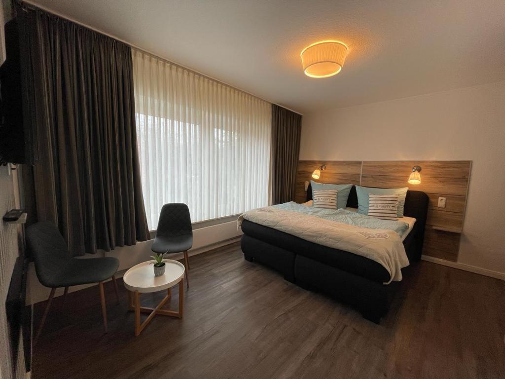 库克斯港Hotel Deutsches Haus的配有一张床和一把椅子的酒店客房