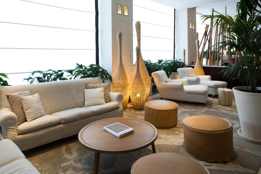 博洛尼亚星际埃克纱修酒店的带沙发、桌子和植物的客厅