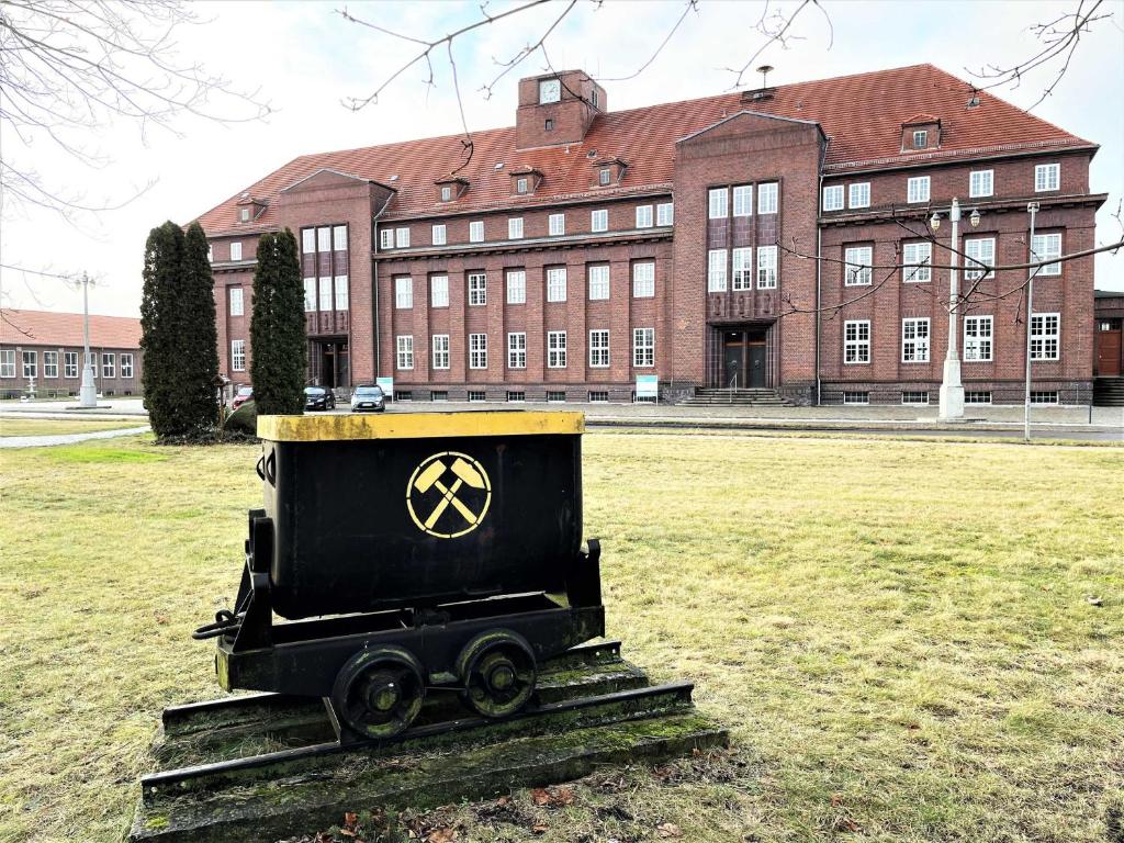 LaubuschIBS Begegnungszentrum的坐在建筑物前方田野上的黑色火车