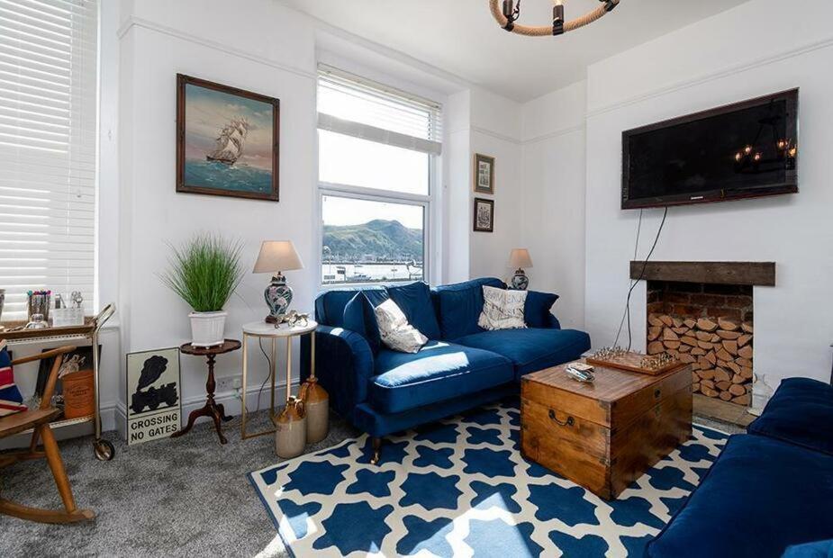 康威Haulfryn Apartment的客厅设有蓝色的沙发和壁炉