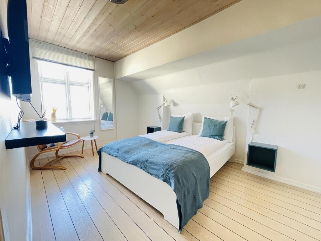 腓特烈港aday - Frederikshavn City Center - Room 5的一间卧室配有一张床、一张书桌和一个窗户。