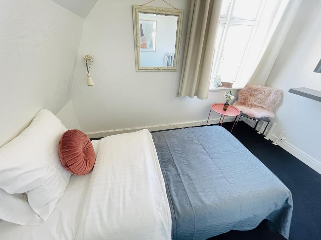腓特烈港aday - Frederikshavn City Center - Single room的一间卧室配有一张床、镜子和窗户