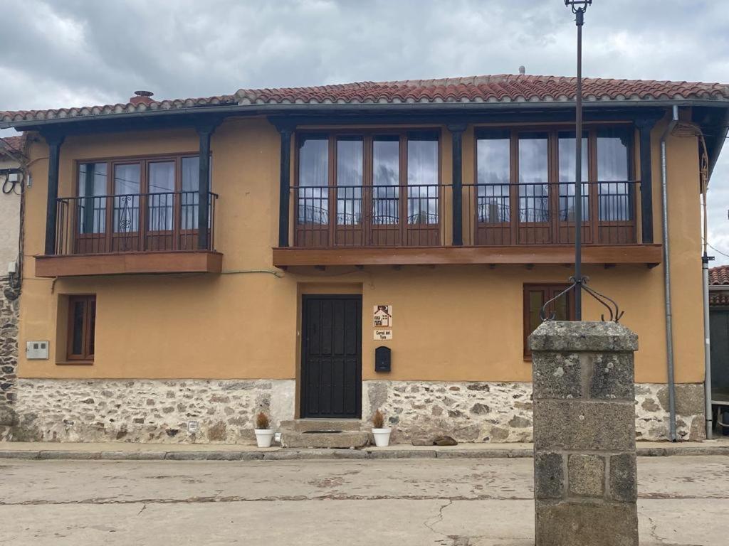 casa rural corral del Toro的黄色房子的顶部设有阳台