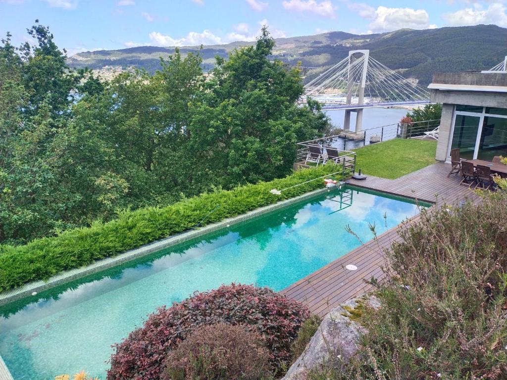 维戈A magical, beautiful villa,stuning views的一座带桥的房屋顶部的游泳池