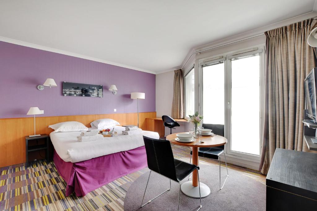 伊西莱穆利诺CMG - Cosy & charmant appartement Paris的酒店客房配有一张床铺和一张桌子。