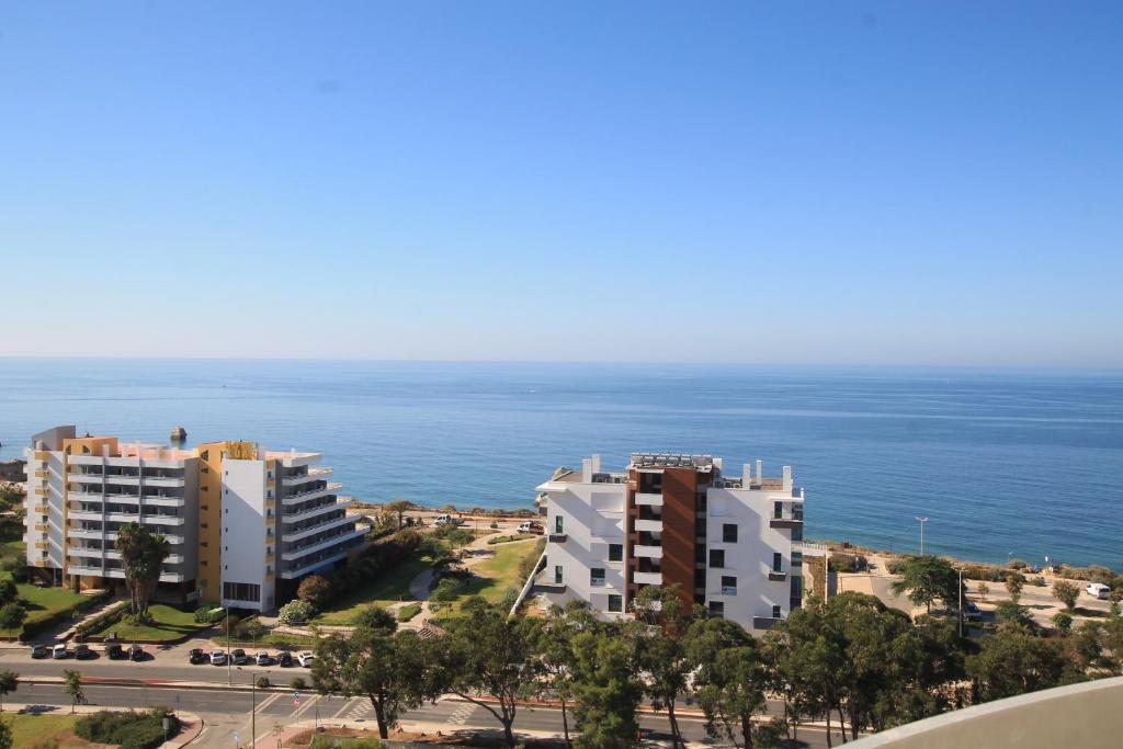 波尔蒂芒Praia_da_Rocha_Vista_Mar/Ocean_View的两栋建筑和大海的景色