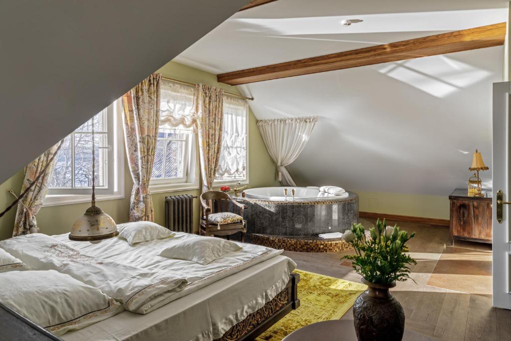 特拉凯阿尔戈特拉凯酒店的一间卧室设有一张大床和一个浴缸