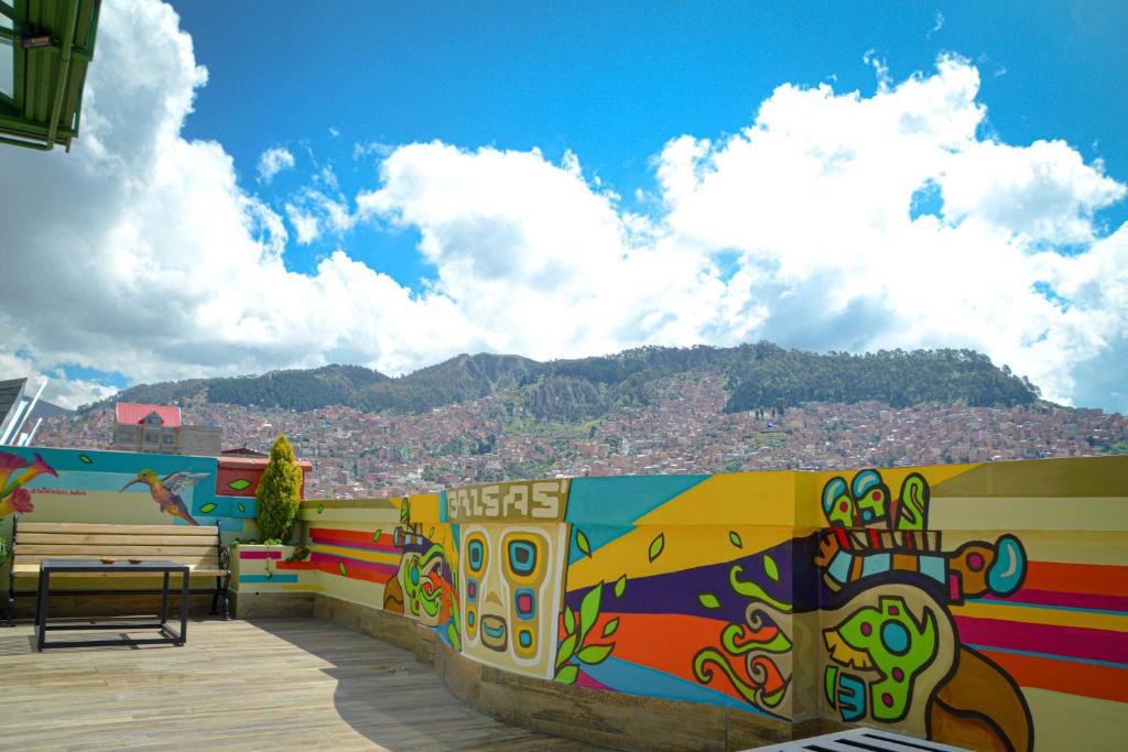 拉巴斯Hotel Las Brisas Centro的长凳和山的五彩墙