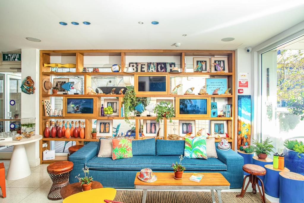 特拉维夫延慕精品特拉斯酒店的客厅设有蓝色的沙发和木架