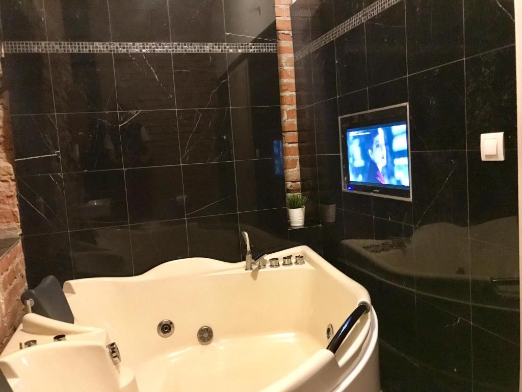 布尔诺Brno center whirlpool apartment的带浴缸的浴室和电视。