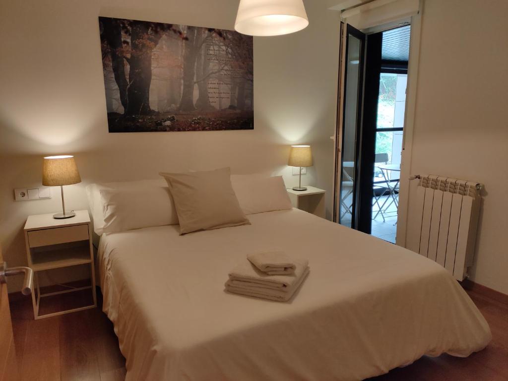 圣塞瓦斯蒂安Ventura Apartment ESS02622的一间卧室配有一张带两盏灯的大型白色床。