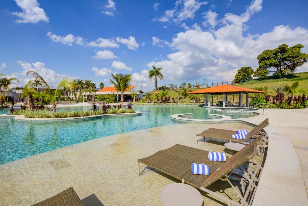 伊图佩瓦Cyan Resort by Atlantica的一个带两把椅子和一张桌子的度假村游泳池