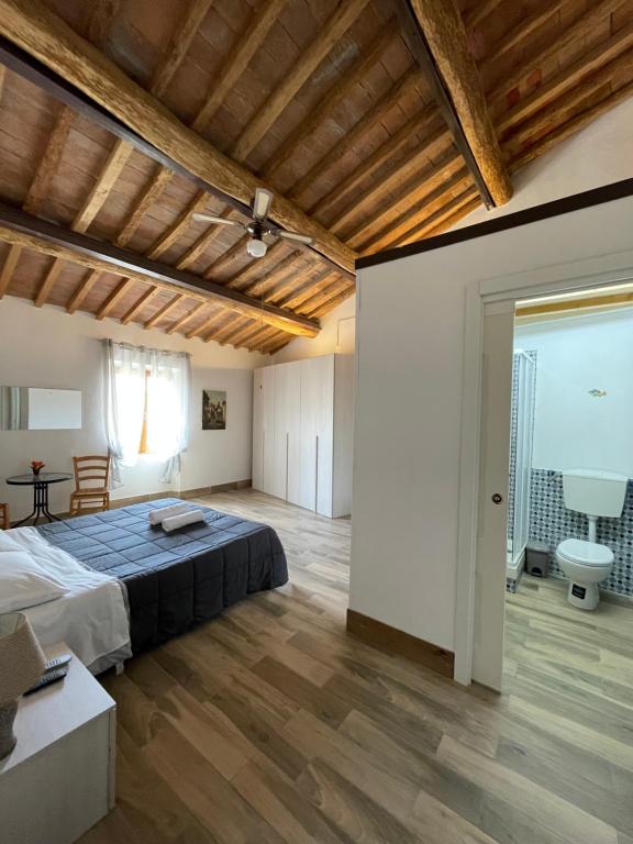 切塔尔多Il Feudo的一间设有床铺和木制天花板的大卧室