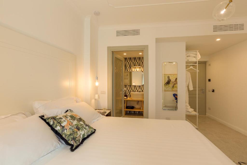 奥尔比亚CasAunoE Boutique Hotel的卧室配有白色的床和枕头
