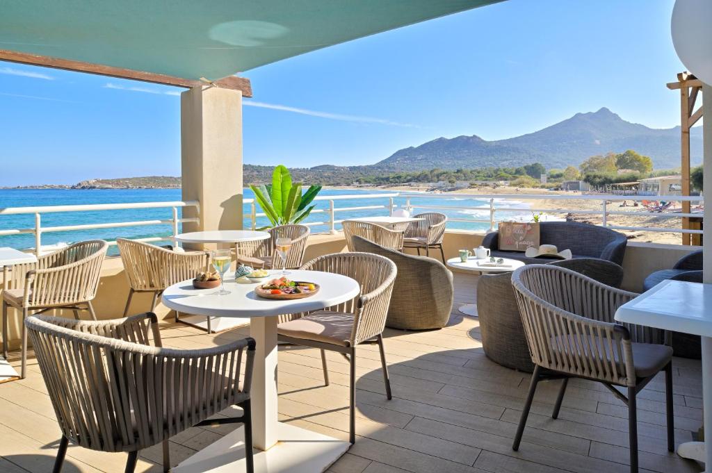 阿尔加约拉贝瑞瓦酒店的一间带桌椅的餐厅,享有海滩美景