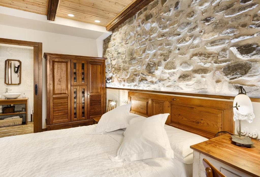 伊萨瓦Casa Rural Francisco Mayo的一间卧室设有一张床和石墙