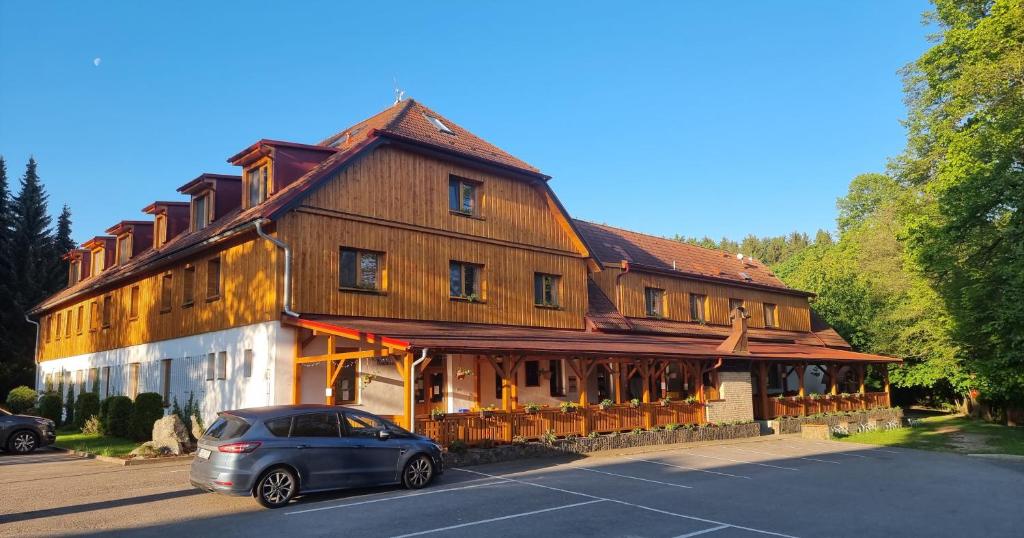 RadešínBalónový hotel a pivovar Radešín的停放在大型木质建筑前的汽车