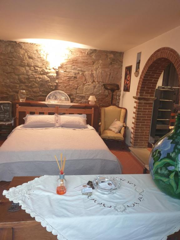 安布拉Helga's House- Una Finestra sul Borgo的一间卧室配有一张床和一张带盘子的桌子