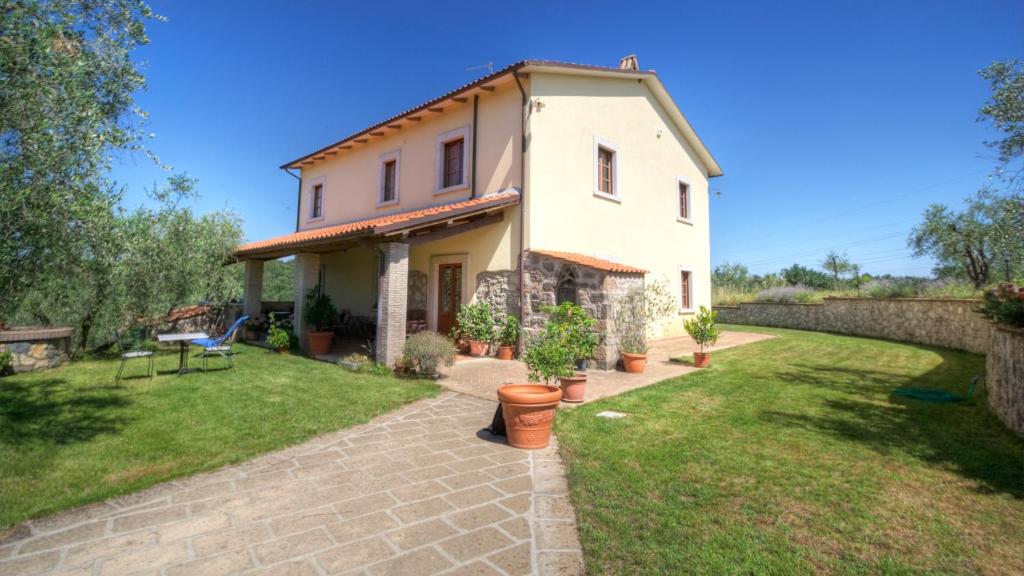 Castiglione in TeverinaIl Poggio Dell'Artilla的一座带草地庭院的白色小房子