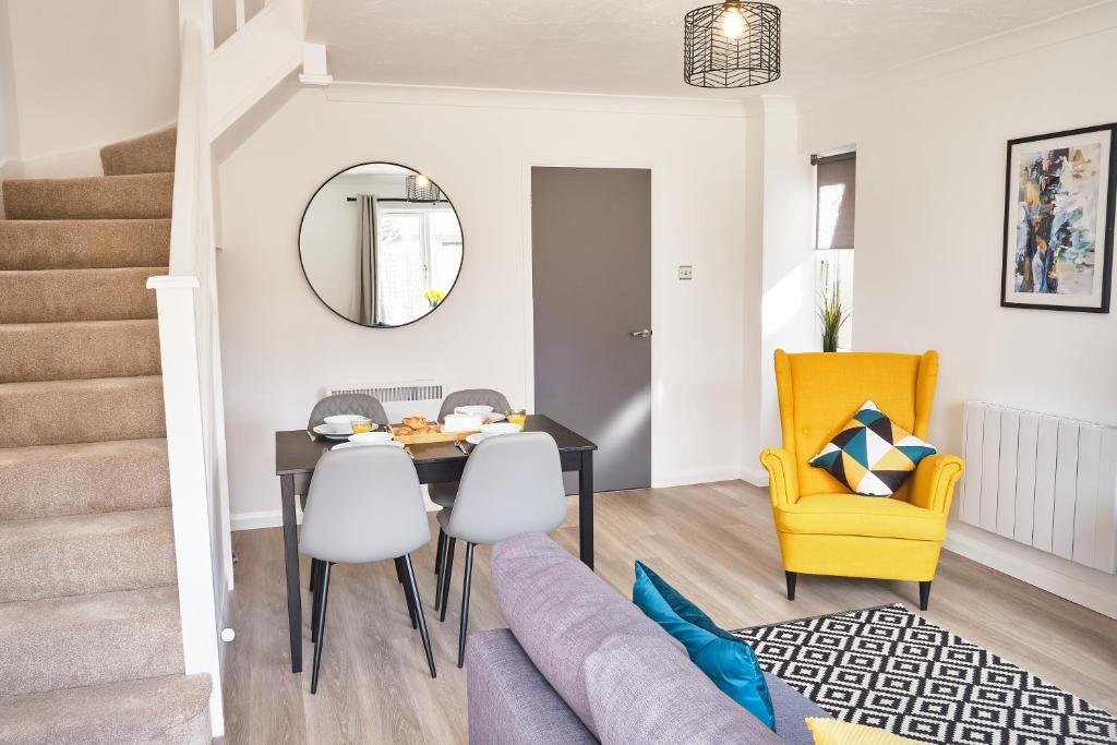 布里斯托Parkway House - Modern with great transport links的用餐室以及带桌子和黄椅的客厅。
