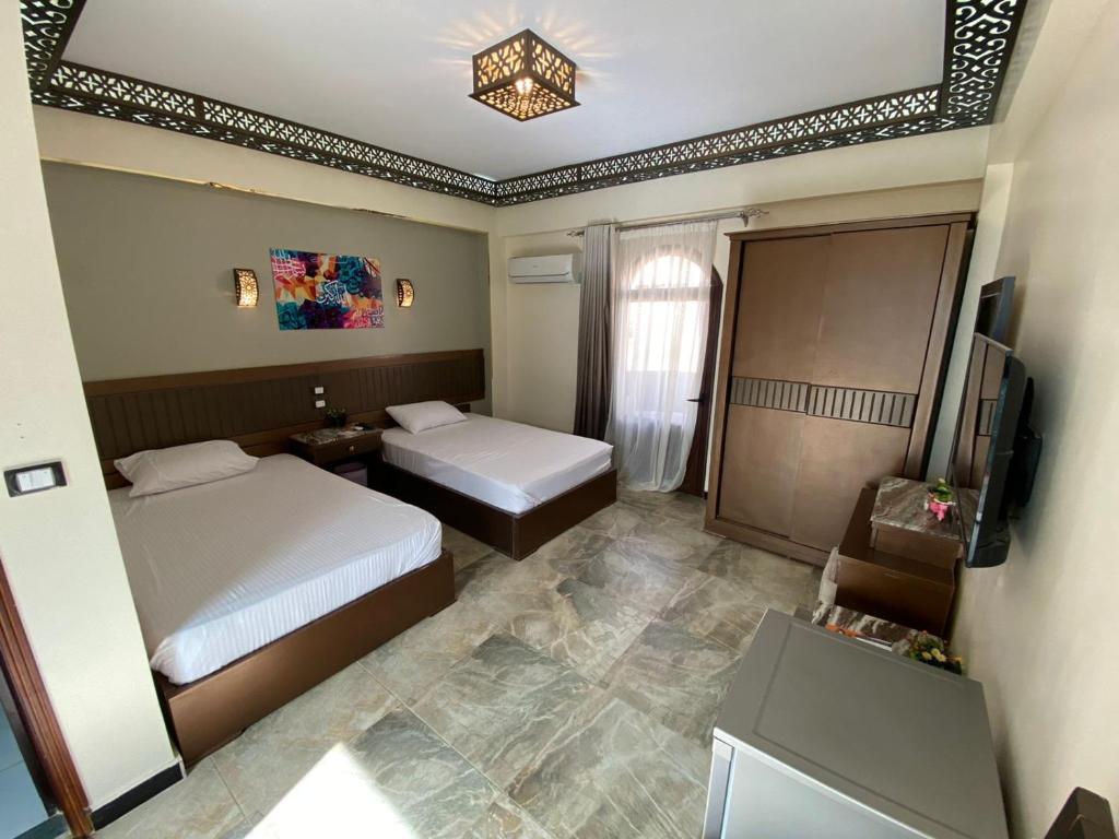达哈布Shabana House的酒店客房设有两张床和电视。
