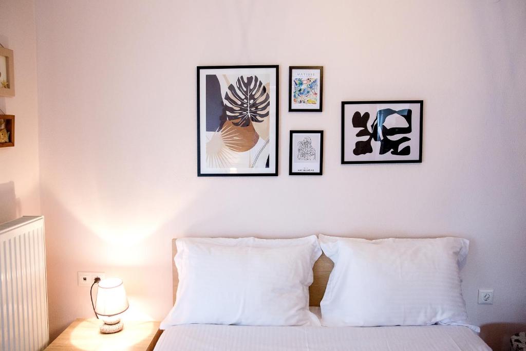 尼亚普拉莫斯Konstantina & Evgenia Deluxe Apartment的卧室配有一张四幅画的墙壁床。