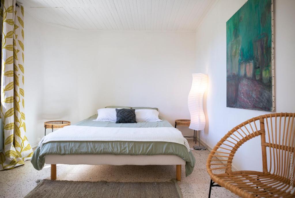 尼姆Maison dans les Arbres, SPA, Tennis, Parking的一间卧室配有一张床和一把椅子
