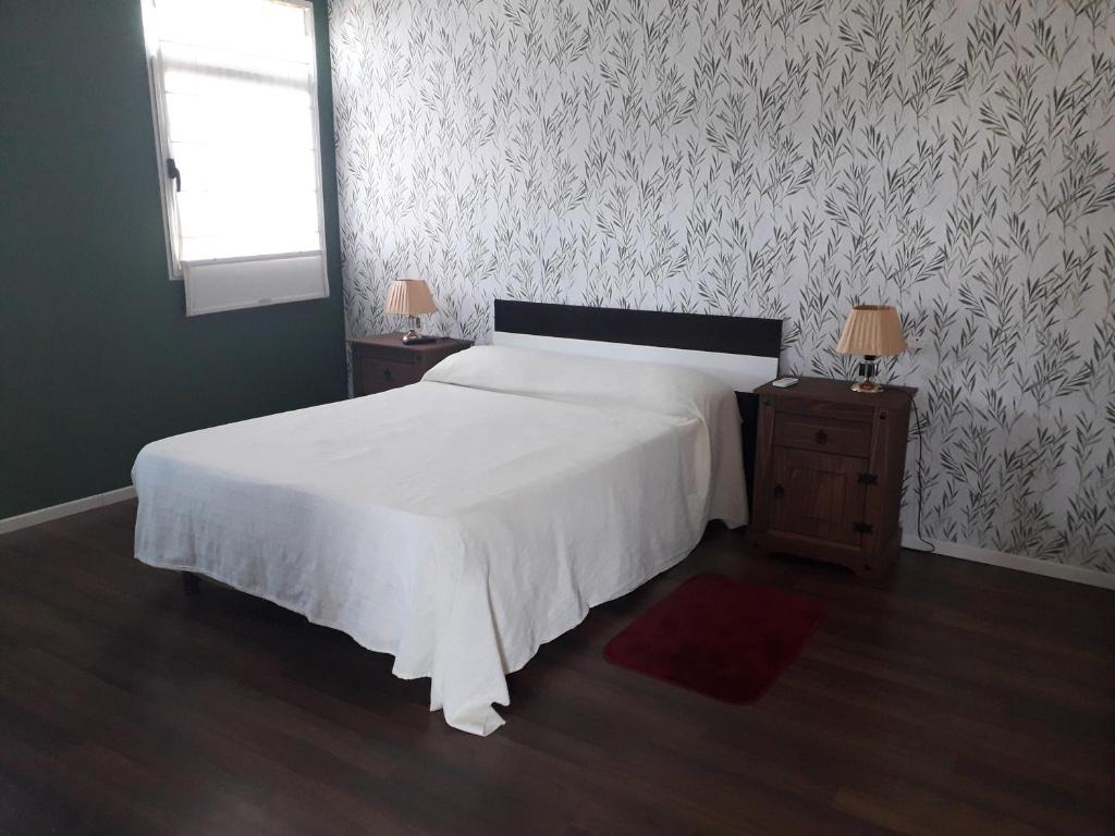 派桑杜RELAX III的卧室配有白色的床和2个床头柜