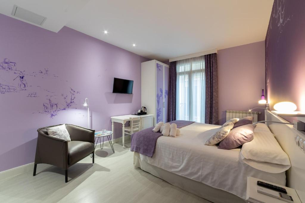 圣塞瓦斯蒂安Ur-Alde的卧室设有紫色墙壁、一张床和一把椅子