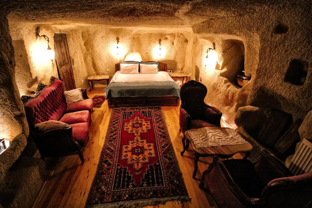 于尔居普patisca cave house in cappadocia的洞穴内带床和椅子的房间