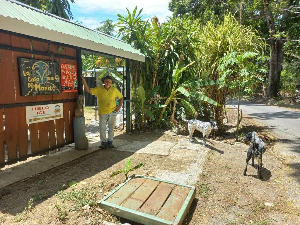 帕克拉Donde Familia Manito的站在建筑物外,有两个狗的男人