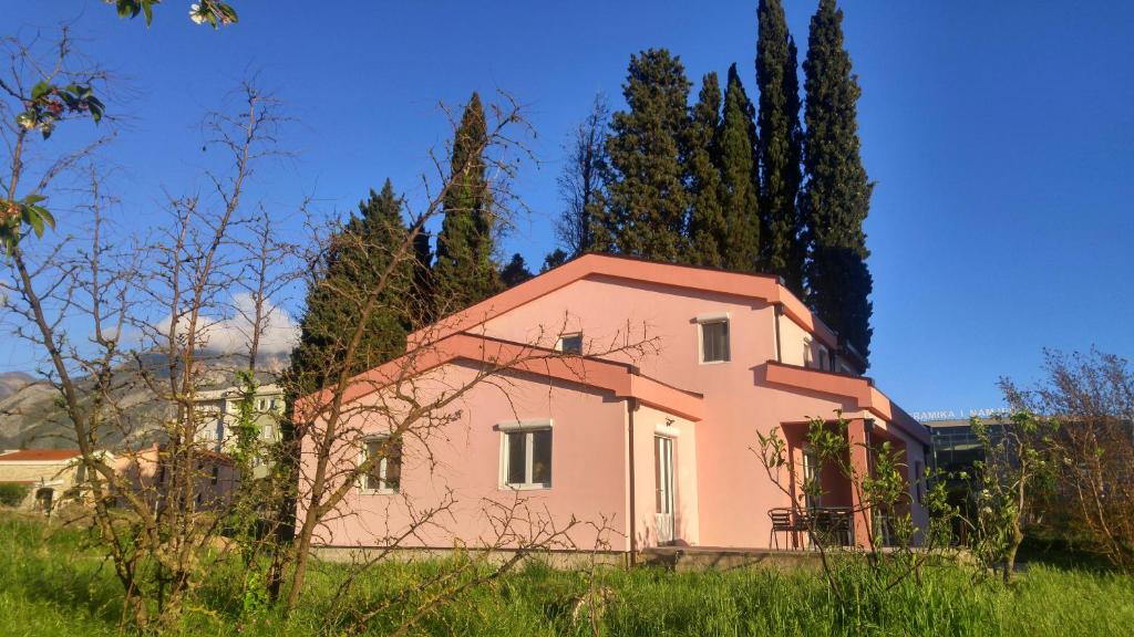 巴尔Hostel Hangout的一片绿树成荫的粉红色房子