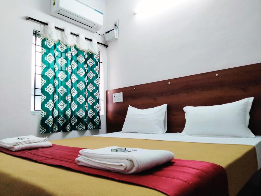 钦奈Royal Green Residency Chennai Airport的酒店客房,配有两张带毛巾的床