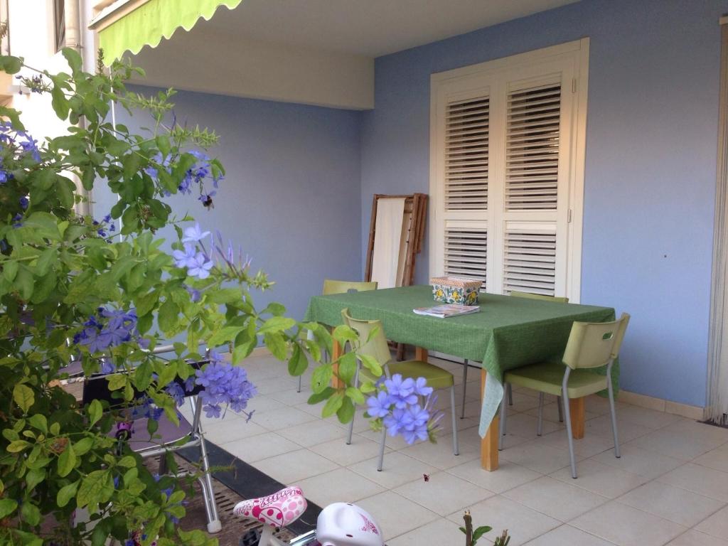 马尔扎梅米Holiday Home Residence Azzurro的紫色花房内的绿色桌椅