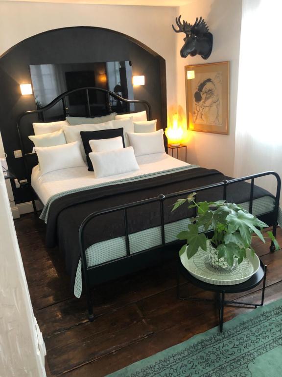 斯特拉斯堡奎壹17号旅馆的卧室配有带白色枕头的大型黑色床