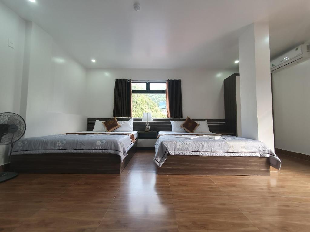 吉婆岛Khách sạn Sông Chanh 3 Cát Bà的大型客房设有2张床和窗户。