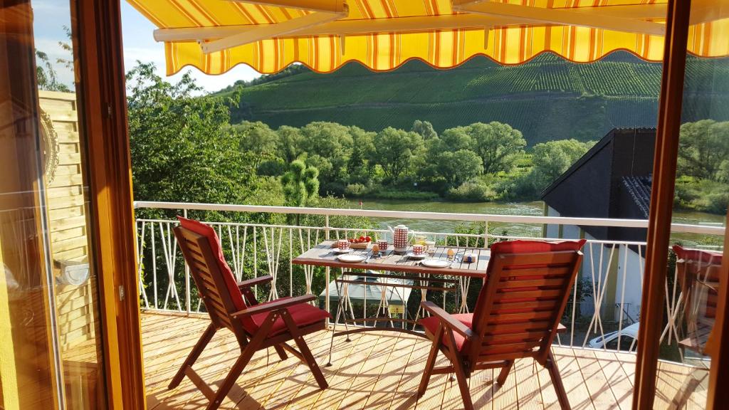 赖尔Casa Barzen - Stilvoll Urlauben an der Mosel的阳台的天井配有桌椅