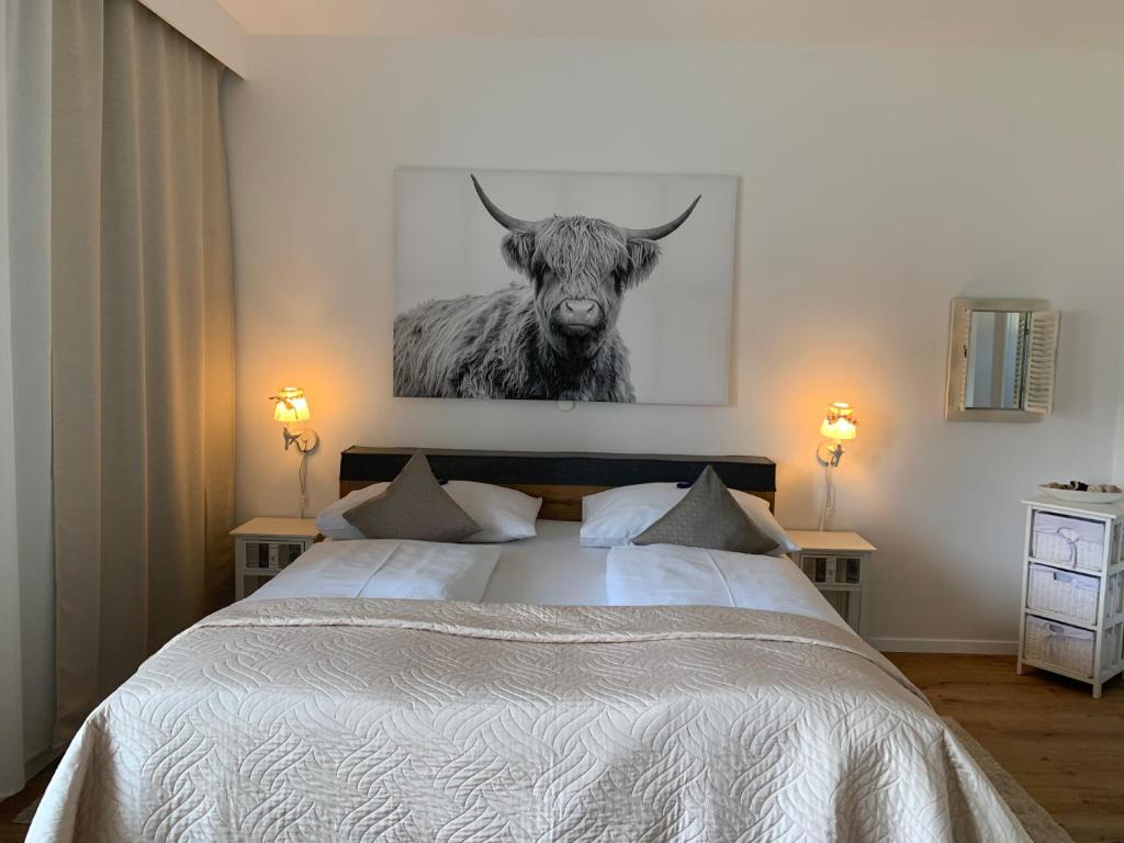 菲拉赫瓦姆巴德公寓酒店的一间卧室,卧室里配有一张带公牛照片的床
