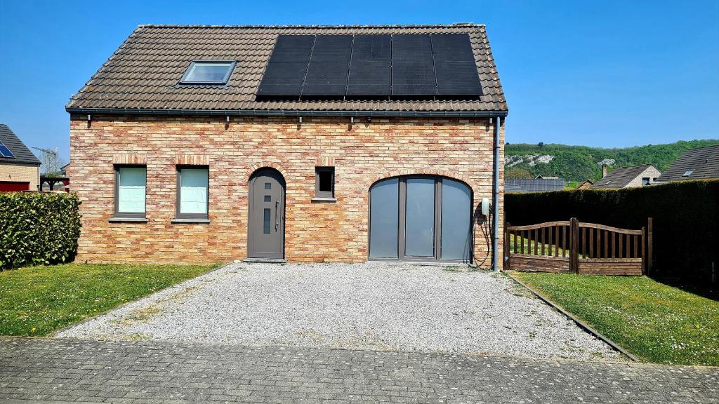 昂内Gîte au 14 - au calme avec jardin , proche de Dinant的屋顶上设有太阳能电池板的砖屋