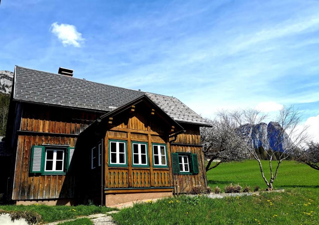 格伦德尔湖Ferienhaus Rosl am Grundlsee的草场上的一个小木房子
