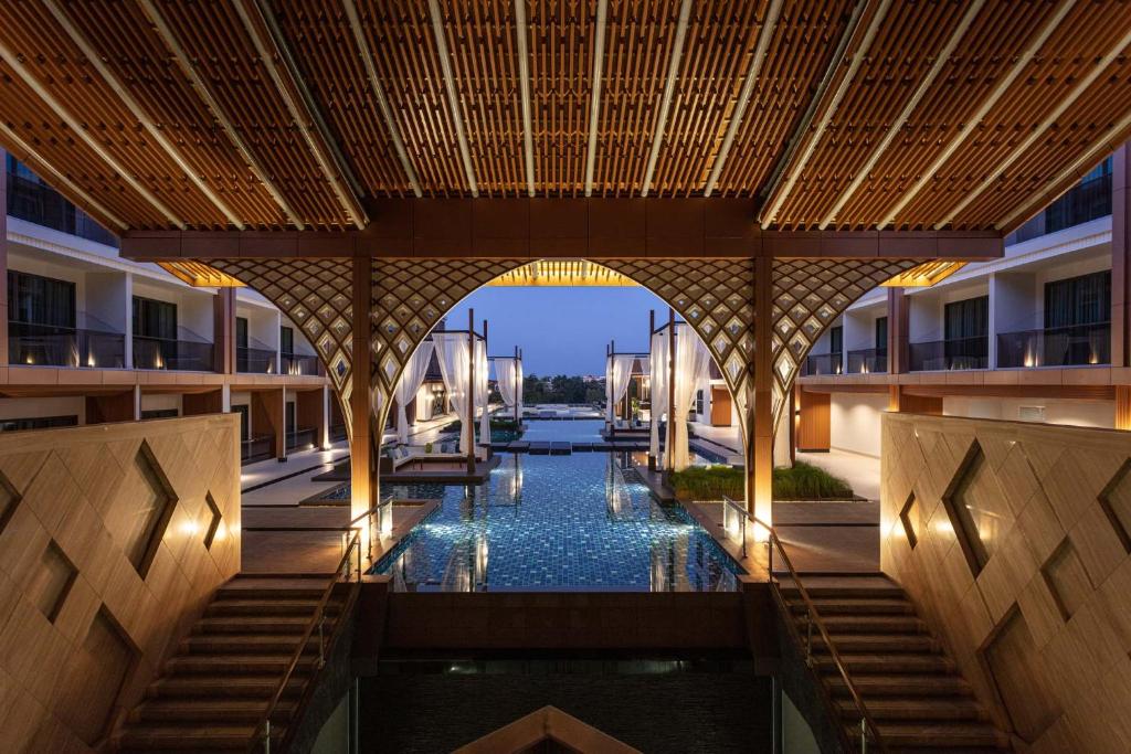宋卡Laguna Grand Hotel & Spa Songkhla的享有酒店内部的景色,中间设有游泳池